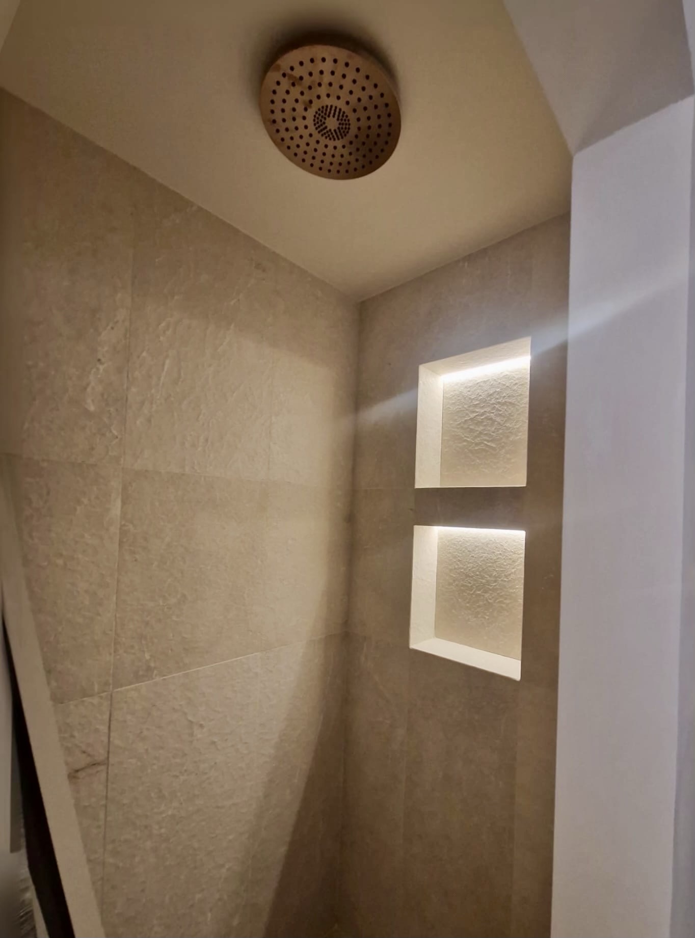 Ducha de obra con hornacinas iluminadas